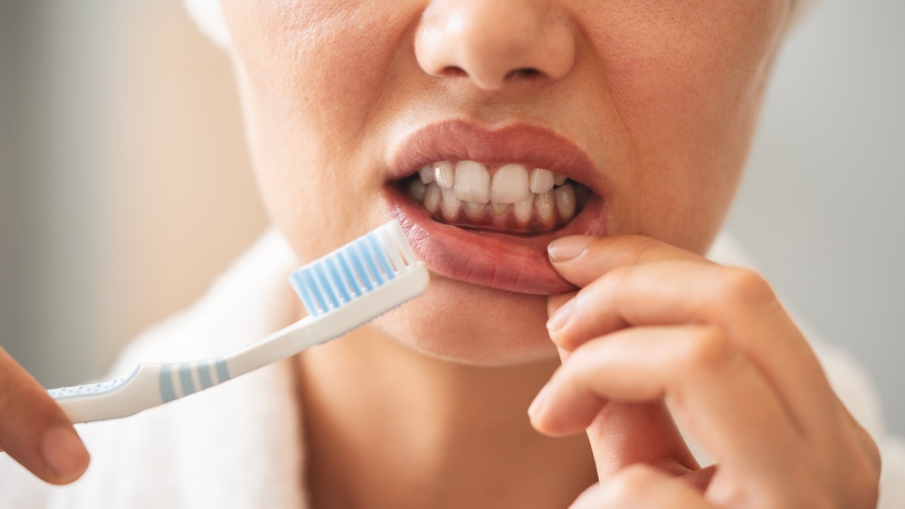 femeie care ii sangereaza gingiile in timpul periajului