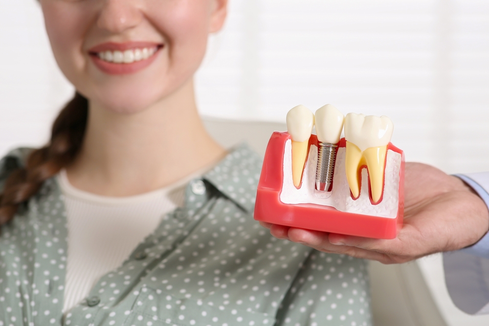 pacienta care zambeste in urma tratamentului cu implant dentar