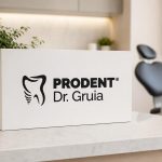 White box with the Prodent Dr. Gruia logo on a marble counter in a bright, modern dental clinic with a blurred treatment chair.
