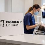Prodent Dr. Gruia clinic sign in the foreground with a blurred dentist performing a procedure on a patient in a modern dental office.